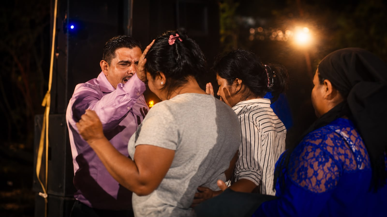 Ministro orando por personas durante una reunión
